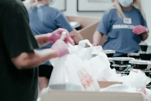 Volunteers pack donated food into bags