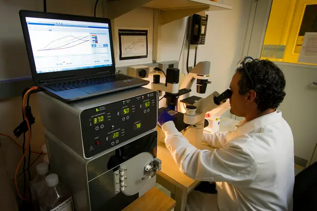 A technician uses a microscope at the National Cancer Institute